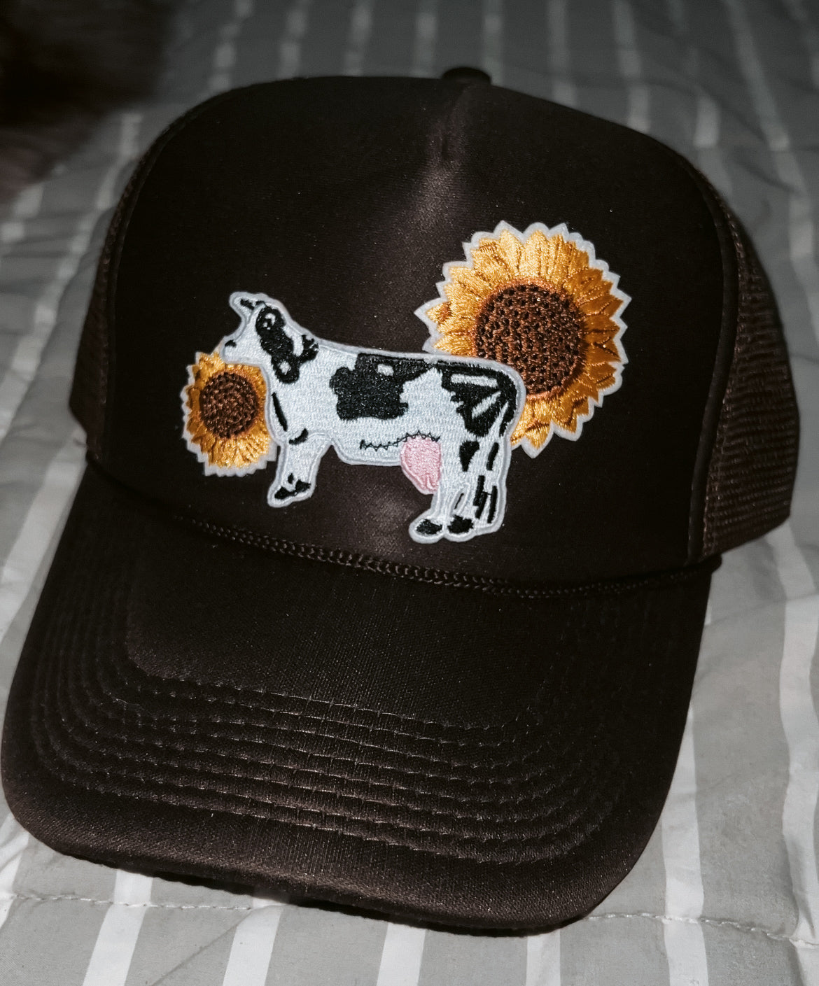 brown hat with black and white cow and two yellow sunflower patches