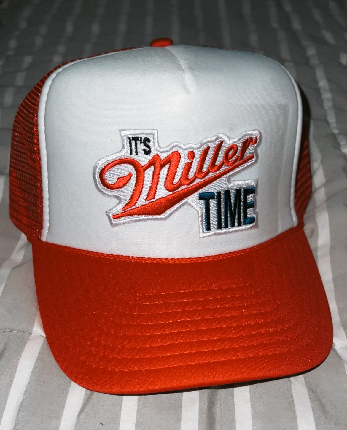 red and white trucker hat with "it's miller time" patch