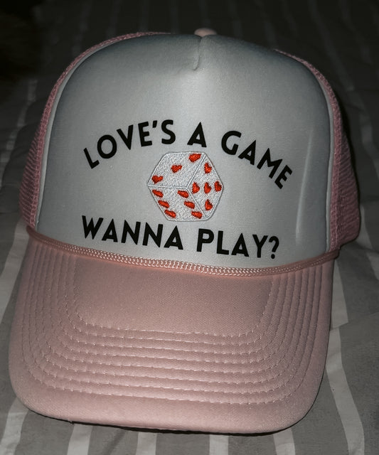 pink and white hat with "loves a game wanna play?" quote and dice patch