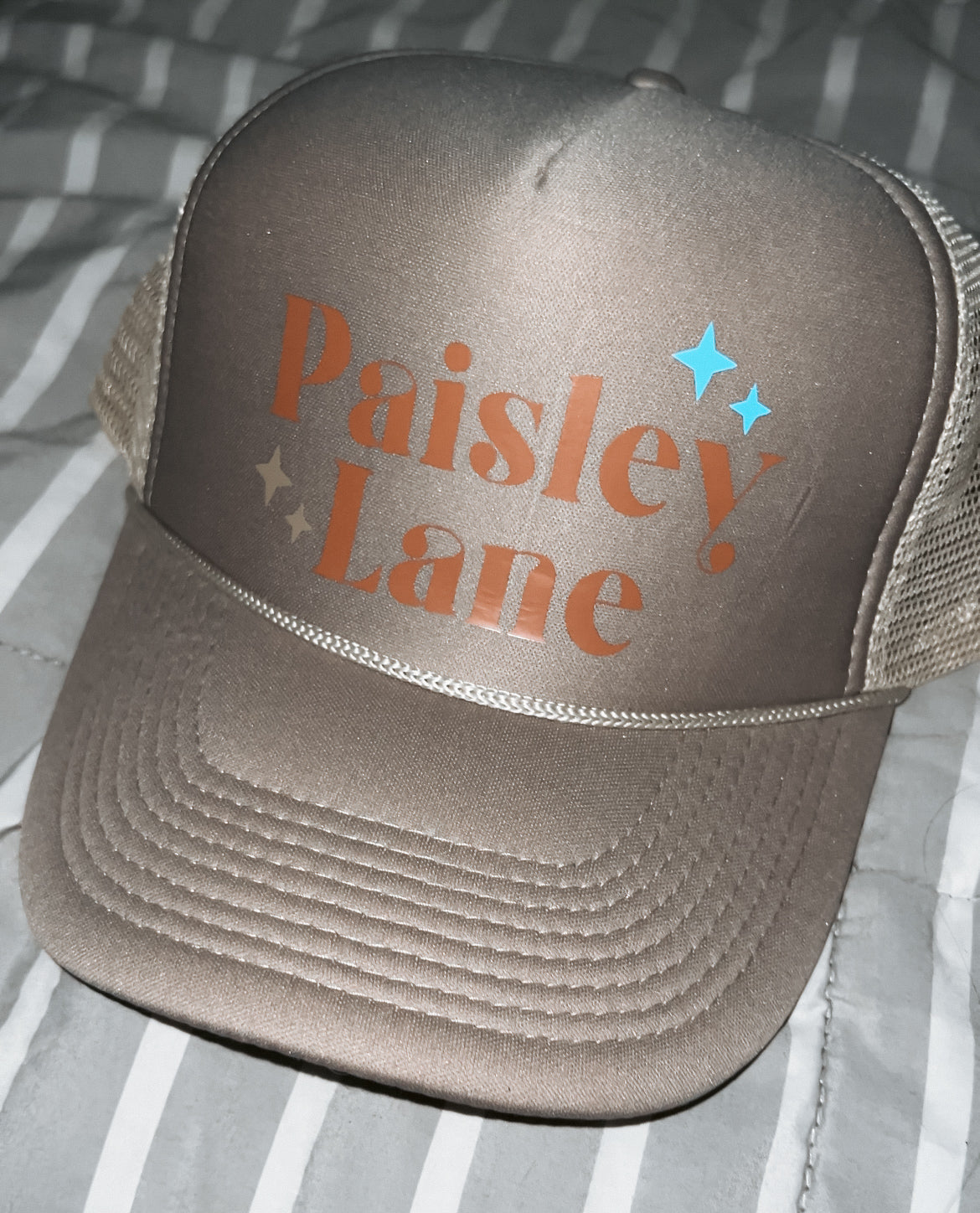 khaki hat with Paisley Lane logo